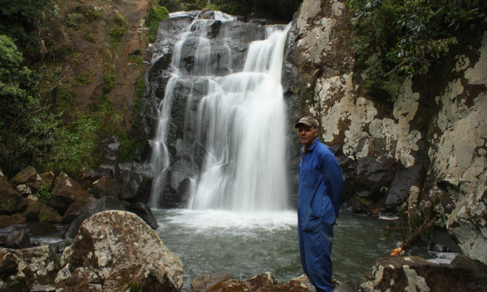 Ian Wilson by a waterfall on the Mangakaraka Stream in the Puketi Scenic Reserve