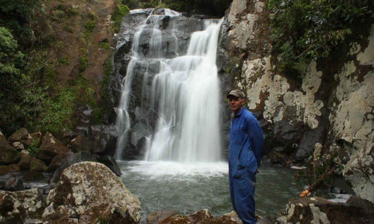 Ian Wilson by a waterfall on the Mangakaraka Stream in the Puketi Scenic Reserve